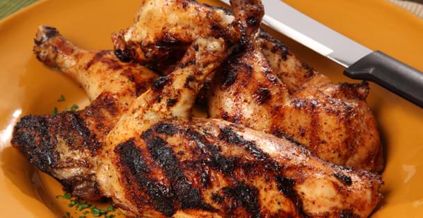 A plate with grilled chicken and a black handled u